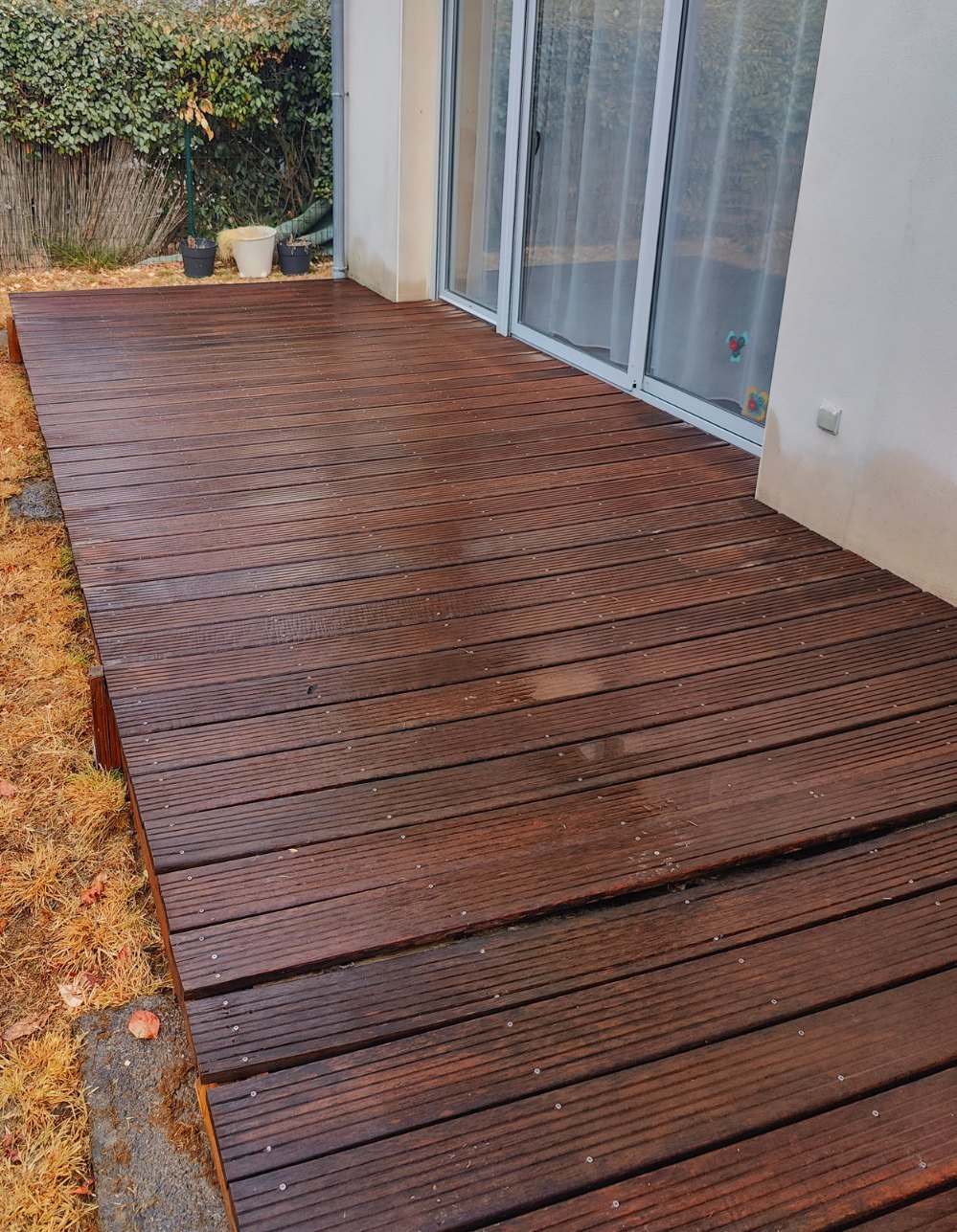 Terrasse en bois exotique devant baie vitrée après nettoyage par La Belle Rosée